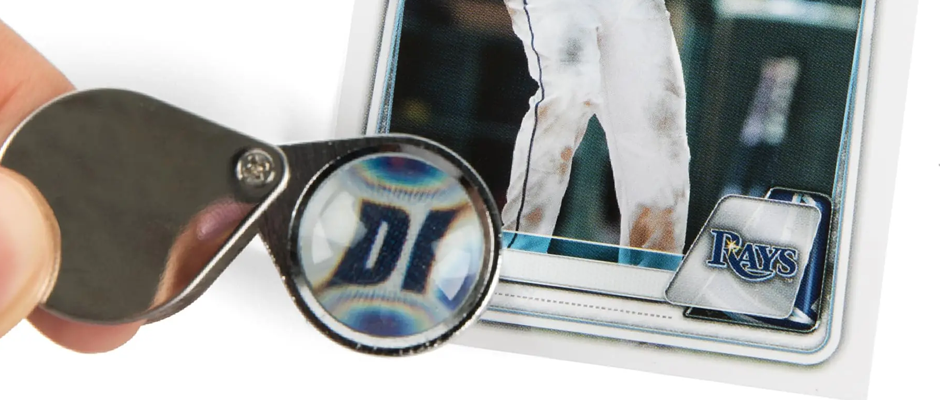pre-grade-cards-at-home-using-a-loupe Using a loupe to get a closer look of sports cards for pre-grading at home purpopes